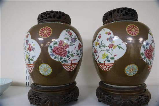 A pair of Chinese export Batavia ware famille rose jars, 18th century, H. 21cm, wood covers and stands